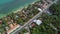 Aerial View of Residental Area with Accommodation and Transport Moving along Road near White Sandy Beach and Sea Shore