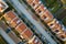 Aerial view of residential houses with red roofs and streets with parked cars in rural town area. Quiet suburbs of a modern