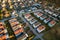 Aerial view of residential houses with red roofs and streets with parked cars in rural town area. Quiet suburbs of a modern