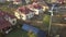 Aerial view of a residential private house with solar panels on roof and wind generator turbine.