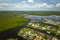 Aerial view of residential suburbs with private homes located near wildlife wetlands with green vegetation on sea shore