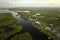 Aerial view of residential suburbs with private homes located near wildlife wetlands with green vegetation on sea shore