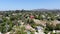 Aerial view of residential villa covered with a red tent while being fumigated for termites.