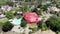 Aerial view of residential villa covered with a red tent while being fumigated for termites.