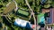 Aerial view of resort with solar panels, pool,parking and green volleyball court with players on it