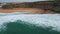 Aerial view rippling ocean waves washing beach. Sea surf covering empty seashore