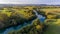 Aerial view of river bending across fields at sunset.