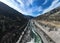 Aerial view of a river flowing through a winding valley and rolling mountains in the background