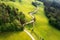 Aerial view of road in green alpine meadows and hills at sunset