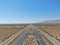 Aerial view of road in the middle of the desert under blue sky in California`s Mojave desert, near Ridgecrest.