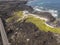 Aerial view of a road that runs through lava fields between the indented coastline of Lanzarote. Spain