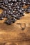 Aerial view of roasted coffee beans on rustic wooden table, vertical