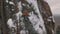 Aerial view of a rock climber climbing a steep cliffs during a sunny winter day.