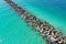Aerial view of rock jetty surrounded by clear shallow water of Miami Beach, Florida.