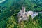 aerial view rock with medieval castle Ehrenburg on it near moselle river in Brodenbach with forest hills