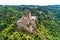 aerial view rock with medieval castle Ehrenburg on it near moselle river in Brodenbach with forest hills