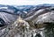 Aerial view rock with medieval castle on it near moselle river in Brodenbach winter with forest snow in the background