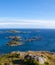 Aerial view of rocks in sea, blue sky in Lofoten Islands, Norway. Summer vertical landscape with small islands in blue water. View