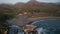 Aerial view of a rocky coastline with splashing waves at soft sunset