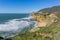 Aerial view of the rocky Pacific Ocean shoreline and scenic highway near Devil`s Slide, California