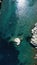 Aerial view of the rocky shoreline of Corfu, Greece with its crystal clear blue ocean waters.