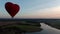 Aerial view romantic balloon flight in the form of a large red heart at sunset.