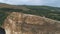 Aerial view on during romantic stroll guy shows girl finger into the distance on cliff, aerial shooting