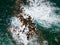 Aerial view of a rough sea crashing against rocks next to a lighthouse (Chania, Crete, Greece