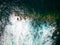 Aerial view of a rough sea crashing against rocks next to a lighthouse (Chania, Crete, Greece