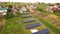 Aerial view of a row of  blue solar panels installed on the ground in residential area.
