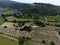 Aerial view on rows of vineyards, green fiels and Lacoste village in Luberon, Provence, France in July