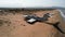 Aerial view of a ruined abandoned airplane found in an uninhabited island near the sea on blue sky background. Action