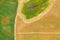 Aerial View Of Rural Landscape. Combine Harvester Working In Field, Collects Seeds. Harvesting Of Wheat In Late Summer