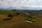 Aerial view of a rural landscape in Tuscany. Rural farm, vineyards, cypress trees, sunlight and clouds. Italy, Europe.