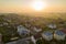 Aerial view of rural residential area with private homes between green fields at sunrise