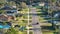 Aerial view of rural street traffic with driving cars in small town. American suburban landscape with private homes in