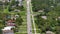 Aerial view of rural street traffic with driving cars in small town. American suburban landscape with private homes in