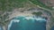 Aerial view of sandy beach with beautiful waves, turquoise ocean water, palms