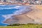 Aerial view of sandy beach in Bodega Bay; Tule Elks sitting on a pasture in Point Reyes National Seashore in the foreground;