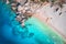 Aerial view of sandy beach with couple and canoe and blue sea