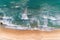 Aerial view sandy beach and crashing waves on sandy shore Beautiful tropical sea in the morning summer season image by Aerial view