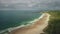 Aerial view sandy beach: ocean foamy waves drops to coastline in White Beach, Antrim County