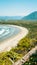 Aerial view of a sandy beach overlooking the vast expanse of the ocean in Cox Bay