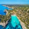 Aerial view of sandy beach with people, boats, azure sea