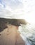 Aerial view from a sandy beach at the sunset with an amazing cliff