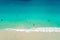 Aerial view of sandy beach with tourists swimming in beautiful clear sea water