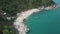 Aerial view of scenery beach. Travel to wild jungles of Thailand. Sea waves leak white sand. Palm trees pass below the