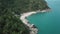 Aerial view of scenery beach. Travel to wild jungles of Thailand. Sea waves leak white sand. Palm trees pass below the