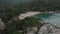 Aerial view of scenery beach. Travel to wild jungles of Thailand. Sea waves leak white sand. Palm trees pass below the