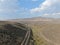 Aerial view of scenic road in the middle of green desert valley in Mono County